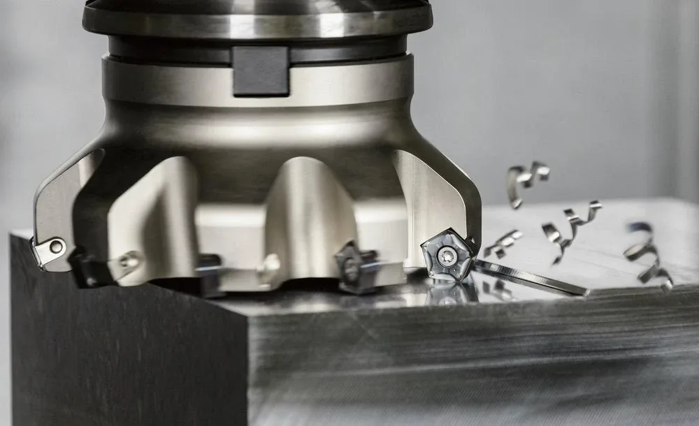 Indexable face mill cutting a flat face on a steel block